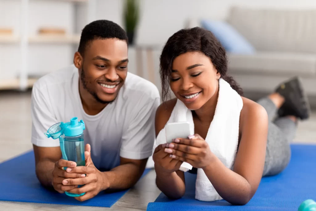 happy couple relaxing after workout at home utc