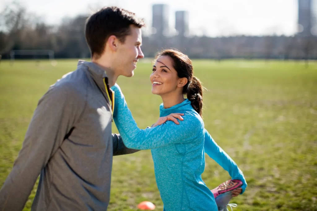 young woman and man doing warm up stretch training utc