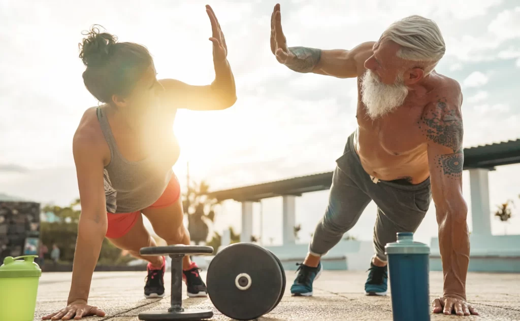 fit woman and senior man exercising outdoors utc